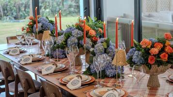 A table set for a meal with candles, glassware, and floral centerpieces.