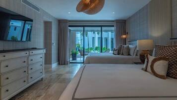 A modern hotel room with a large bed, a television, a dresser, and a view of the outdoors.