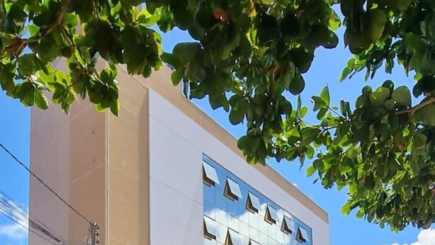 A multi-story building with a modern architectural design, featuring a prominent glass facade and a sign for 'LaundryHome'. - Flats Uno - By EasyHost (João Pessoa)