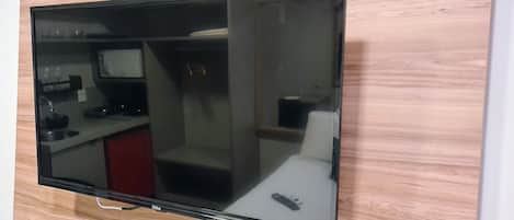 A flat-screen TV mounted on a wall with a wooden panel design.
