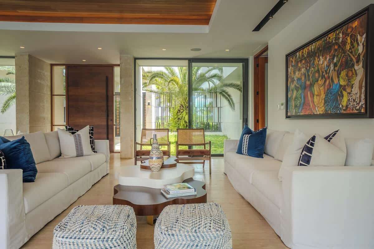 A modern living room with two sofas, a coffee table, and a large painting.