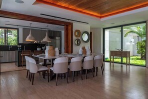 Una cocina moderna con comedor, ventanas amplias y vistas a zonas verdes.