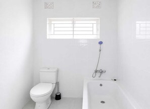 Une salle de bain comprenant des toilettes, un bidet et une baignoire.
