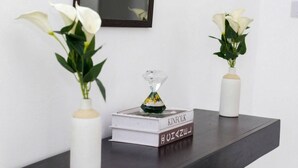 A dark wooden table with two white vases containing white flowers and a book titled 'KINFOLK' with Japanese characters.