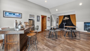 Een moderne keuken met een bar, houten vloeren en een eethoek met krukken.