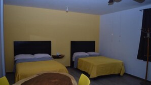 Quarto com duas camas, uma mesa de madeira e cadeiras.