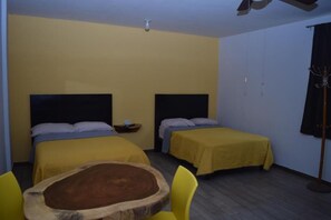 A room with two beds, a wooden table, and chairs. - Estancia Vacacional 20 Aguas (Ursulo Galvan)