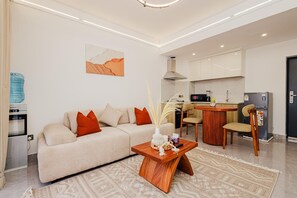 Ein stilvolles Wohnzimmer mit einer Couch, einem Couchtisch und einem Essbereich mit Stühlen.