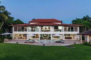 A two-story house with a swimming pool, outdoor seating, and a well-maintained lawn. - Villa Vega de Palma. Luxurious villa .Golf view (La Romana)
