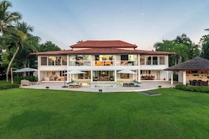 Une maison à deux étages dotée d’un grand patio, de meubles d’extérieur et d’une piscine.