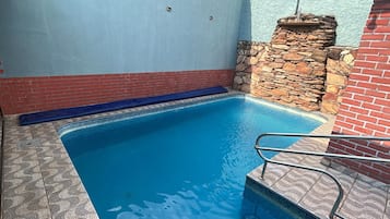 Ein Swimmingpool mit einer Steinmauer und einem blauen Handtuch.