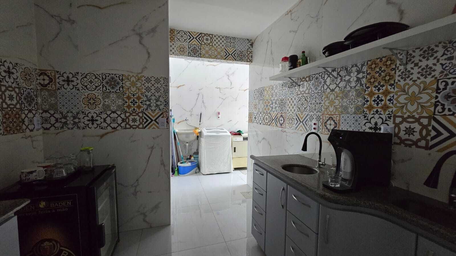 A kitchen with a marble backsplash, a sink, and a countertop.