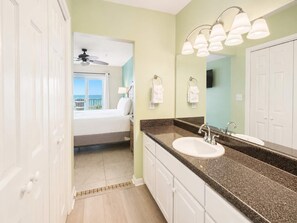 Ein Hotelbad mit großem Spiegel, Waschbecken und Deckenventilator.