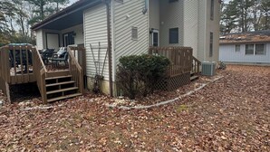Ein einstöckiges Haus mit einer Veranda und einer kleinen Terrasse.