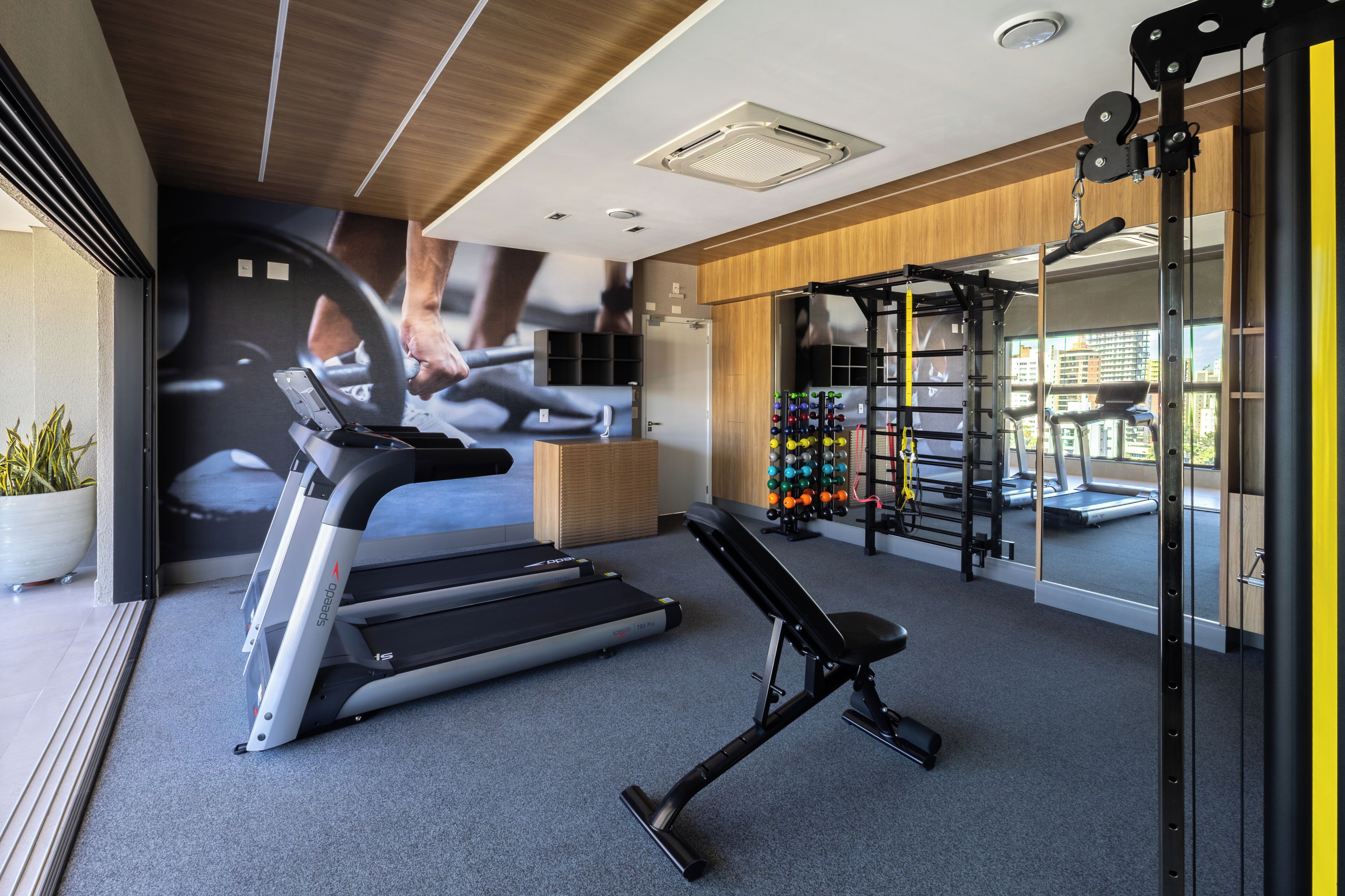 A gym with treadmills, a bench, and a weight rack.