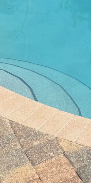Une piscine à l’eau d’un bleu limpide, dont les bords sont recouverts de carreaux.