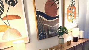 A wooden reception desk with a lamp, a potted plant, and framed artwork on the wall. - Spacious 5-bedroom Modern Retreat with Heated Pool Near Beach and Cove Shopping (Deerfield Beach)