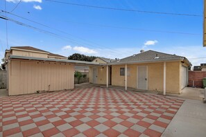 Un garage attenant à une maison, doté d’un sol à carreaux, d’une allée couverte et d’une seule porte de garage.