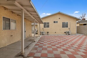 A building with a covered patio area, air conditioning units, and a checkered floor. - Alhambra Studio for 4 - Two Queen Beds, Kitchen, WiFi (Alhambra)