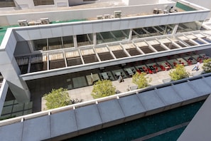 A modern building with a glass atrium, outdoor seating, and a pool area. - 1BR Apt, Full Condo, Jardim Goias - Mbca0407 (Goiânia)