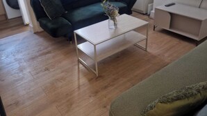 A living room with a sofa, a coffee table, a television, and a cabinet. - 3BR House in Barrow-in-Furness | Near transpo | ST (Barrow-in-Furness)