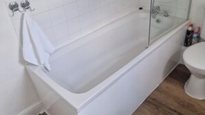 A bathroom with a white bathtub, a glass shower enclosure, and a toilet. - 3BR House in Barrow-in-Furness | Near transpo | ST (Barrow-in-Furness)
