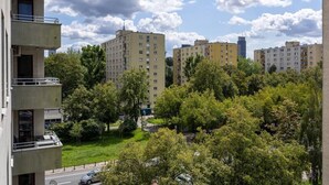 Una zona residenziale con palazzi a più piani, una strada e alberi.