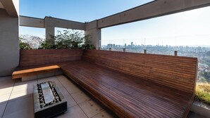 A modern outdoor seating area with a bench and a fire feature. - Ária Higienópolis by WeCare Hosting (São Paulo)