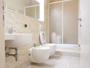 A bathroom with a sink, two toilets, a shower, and a mirror. - Apartment in Piazza del Campo area 3 bedrooms 2 bathrooms (siena)