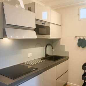 A modern kitchen with a built-in oven, a stainless steel sink, and a sleek countertop. - Top Floor - Top Location (Siena)