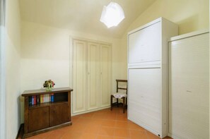 A room with a wooden cabinet, a chair, and a white wardrobe. - A BALCONY ON THE PIAZZA OF THE PALIO (Siena)