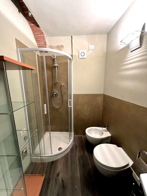 A bathroom with a glass-enclosed shower, a toilet, and a sink. - Very Central Studio close to public parking and il Campo (Siena)