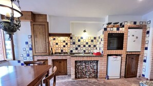 A kitchen with a stone floor, wooden cabinets, a built-in oven, and a refrigerator. - A BALCONY ON THE PIAZZA OF THE PALIO (Siena)