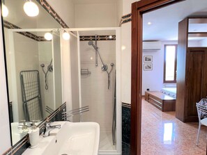 Ein Badezimmer mit Dusche, Waschbecken und Spiegel.