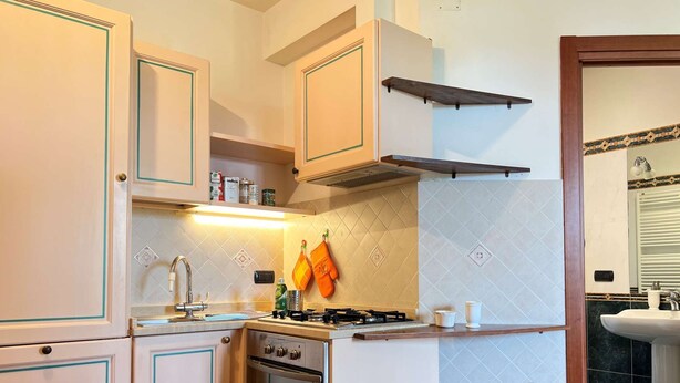 A kitchen with white cabinets, a gas stove, an oven, and a sink. - Cozy Studio 8 in the Heart of Siena (Siena)