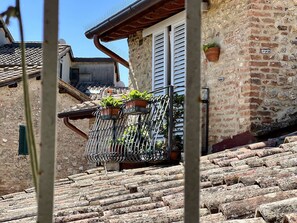 A stone building with a metal staircase leading to a balcony with potted plants. - Astonish cathdral view, Super central (Siena)