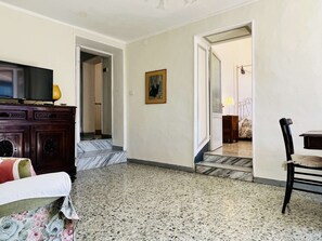 A hotel room with a bed, a TV, a desk, and a chair. There is a painting on the wall and a door leading to another room. - Astonish cathdral view, Super central (Siena)