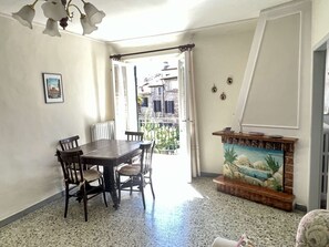 A dining area with a table and chairs, a radiator, a painting on the wall, and a view through an open door. - Astonish cathdral view, Super central (Siena)