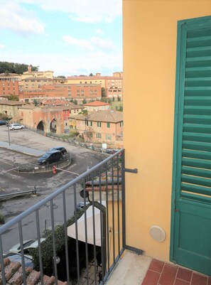 A balcony with a view of a cityscape, including buildings and a roundabout. - A BALCONY ON THE PIAZZA OF THE PALIO (Siena)