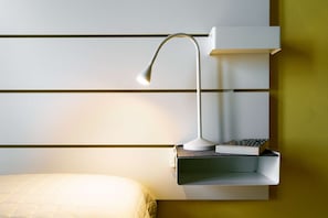 A modern bedside table with a lamp, a book, and a phone. - A BALCONY ON THE PIAZZA OF THE PALIO (Siena)