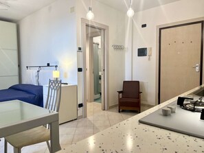 A hotel room with a bed, a desk, a chair, a bathroom, and a kitchenette. - A BALCONY ON THE PIAZZA OF THE PALIO (Siena)