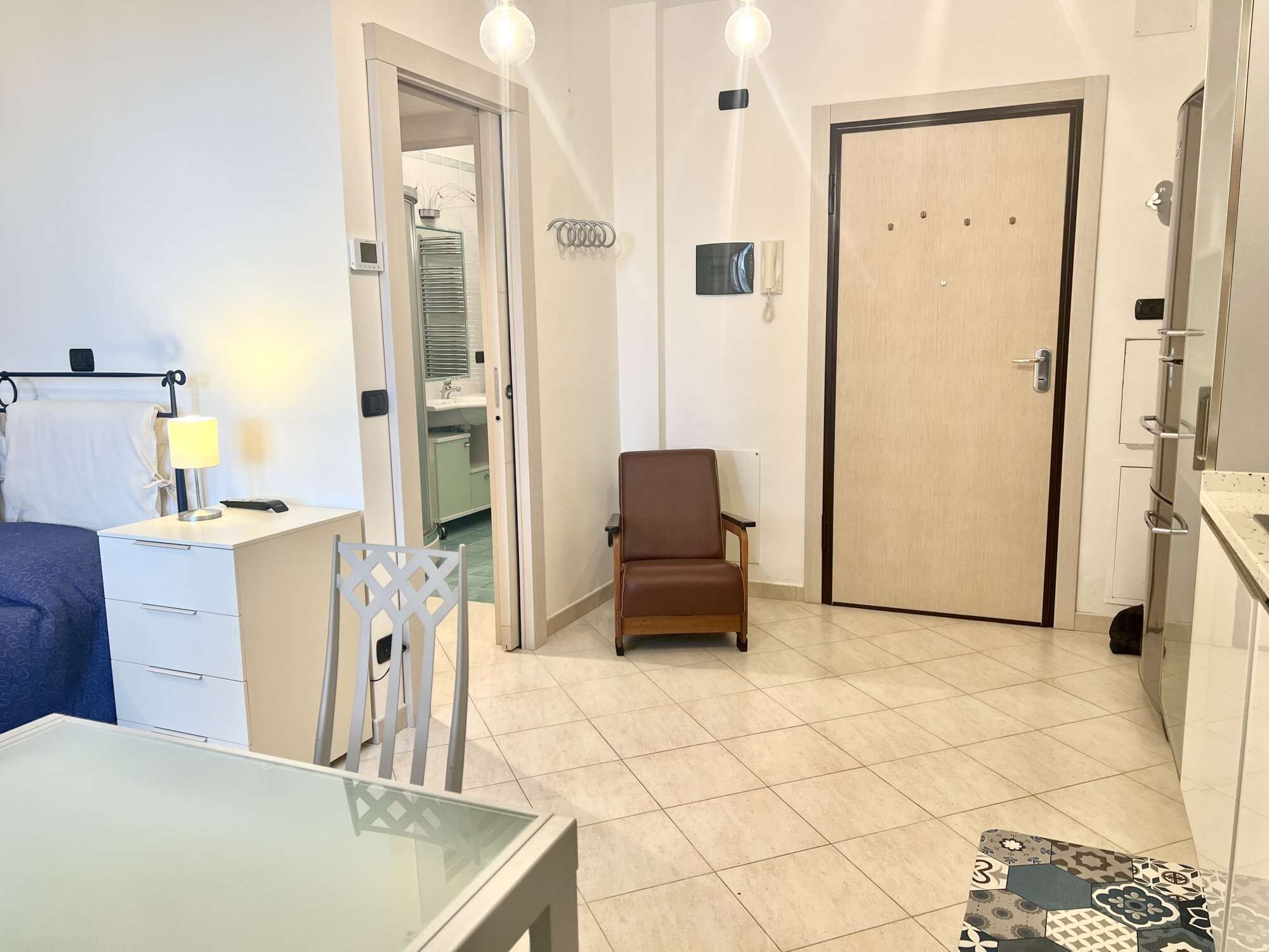 Een compacte leefruimte met een eethoek, een kitchenette en een badkamer.
