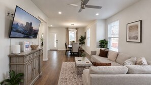 Un salon spacieux avec un canapé, une table basse et un téléviseur fixé au mur.