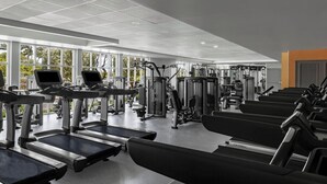 Una palestra con tapis roulant, macchinari per pesi e panche.