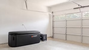 A garage with a large black SunHome sauna unit and a smaller control box.