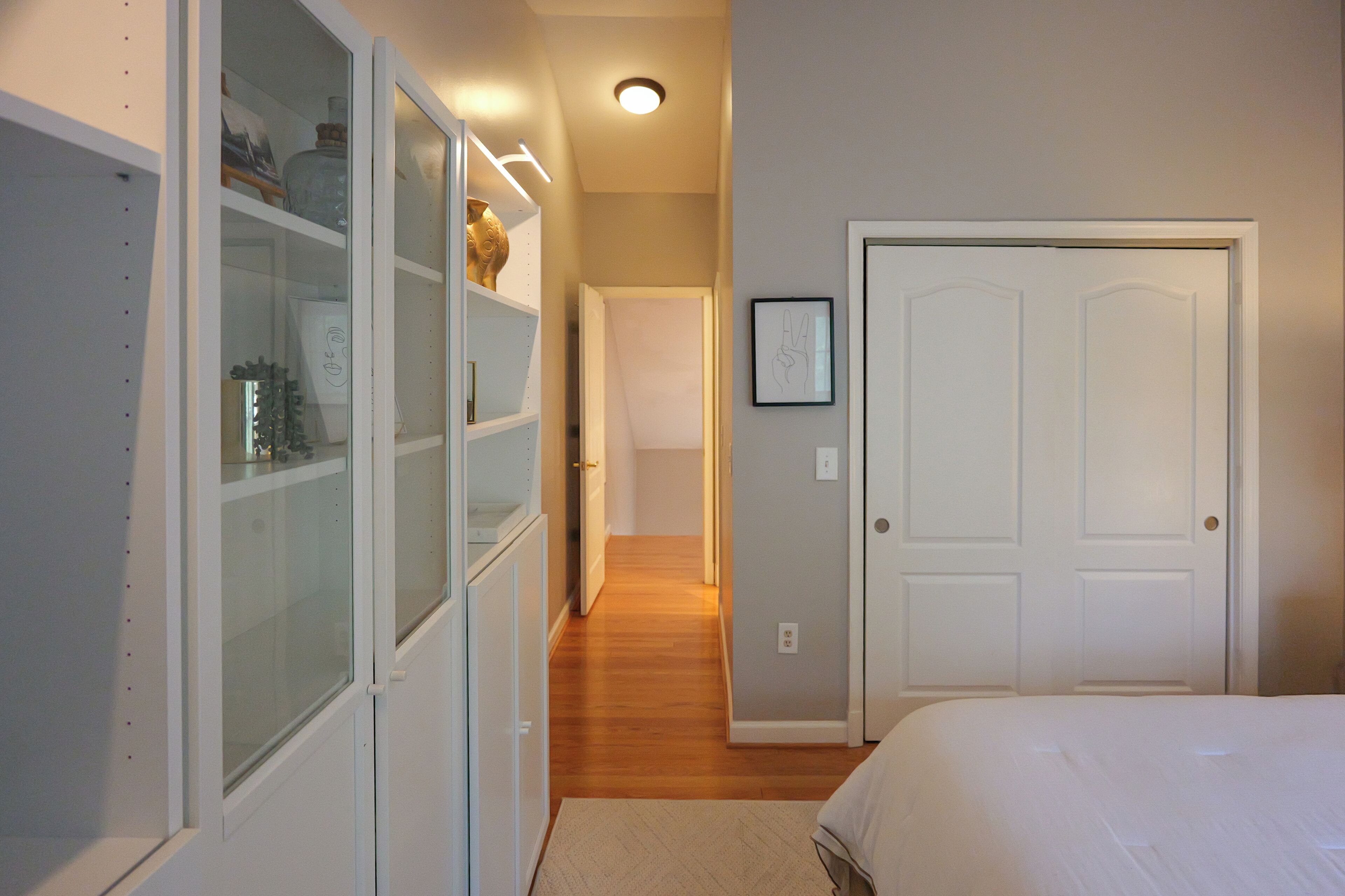 A bedroom with a bed, a wardrobe, and a door.