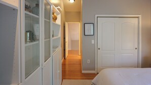 Et soveværelse med seng, garderobe og dør.