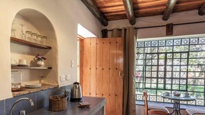 Una cocina con encimera de piedra, una cafetera y una cesta de mimbre.
