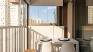 Ein Balkon mit Tisch für zwei Personen, mit Blick auf die Stadt.