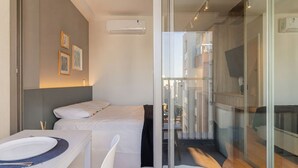 Hotellihuone, jossa on sänky, ruokapöytä ja pieni keittokomero.
